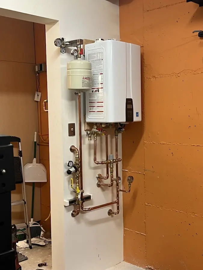 Plumbing technician inspecting water heater connections in Shadyside